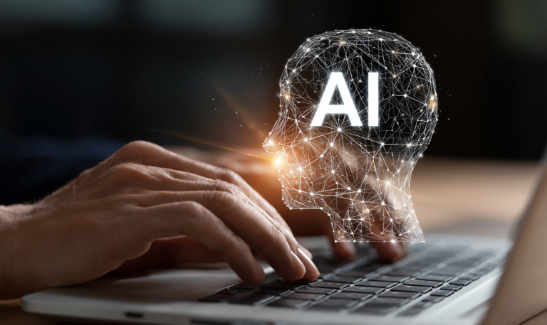 Photo of human hands typing on a laptop keyboard with a digital human head icon and the text "AI"