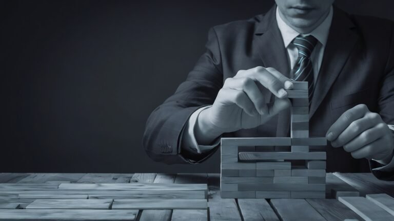 business-man-try-build-wood-block-wooden-table-black-background