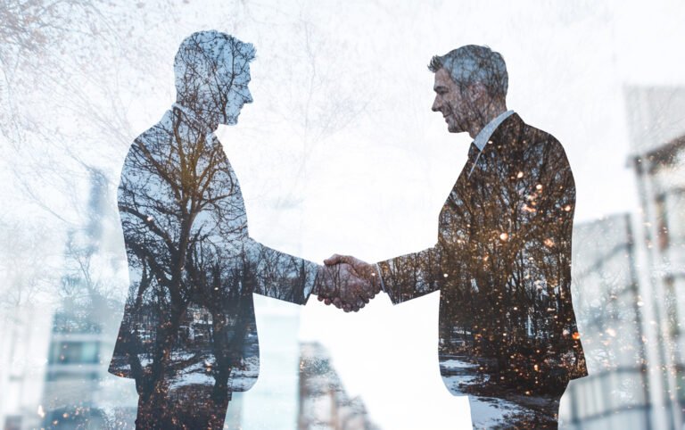 photo-two-business-man-hand-shaking-office-background