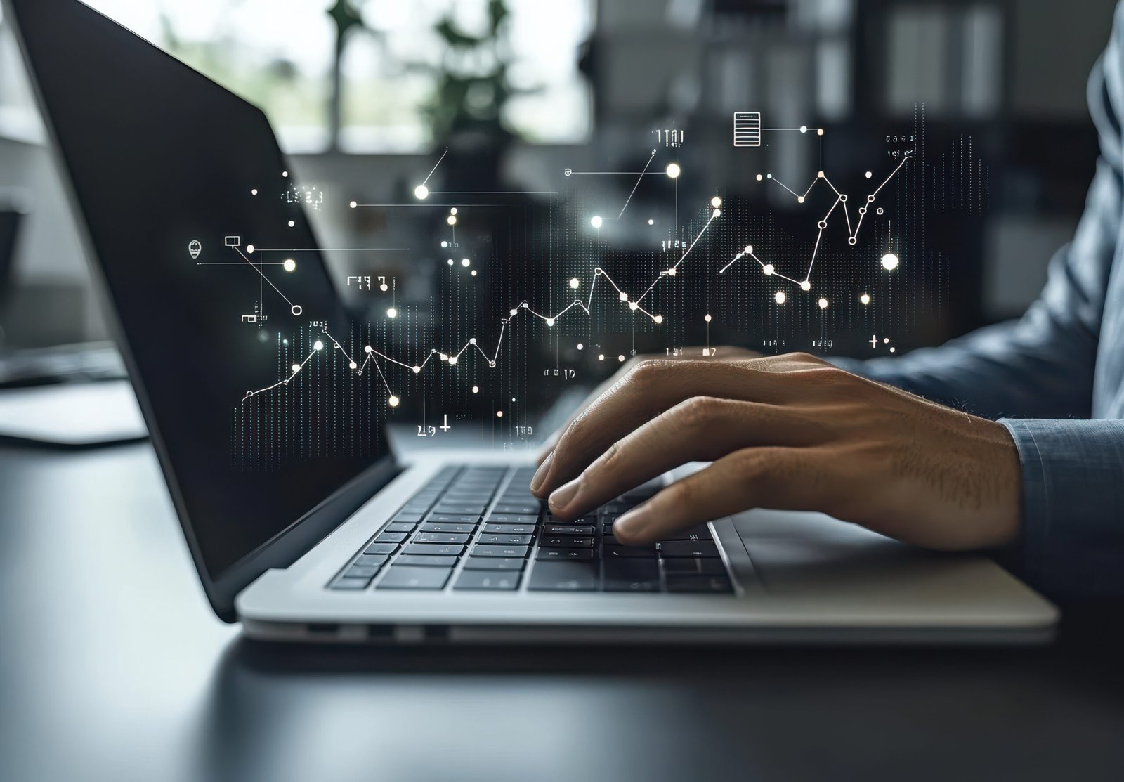 group of business professionals working together in an office, using laptops and tablets to analyze financial data with charts on screen